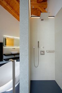 Die Trennwand teilt ein großes Badezimmer in klare Funktionsbereiche.